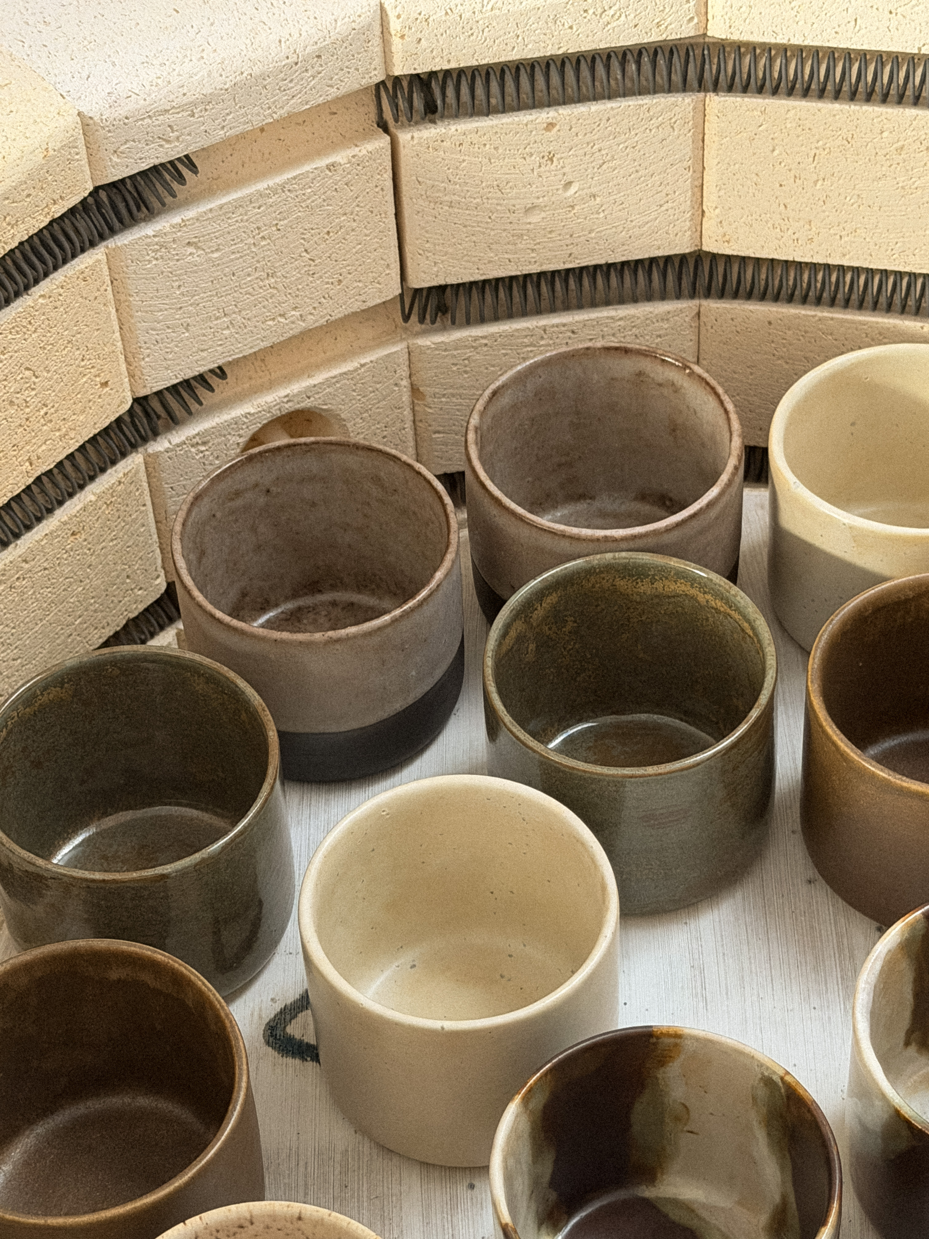 Stacked handmade beige ceramic mugs